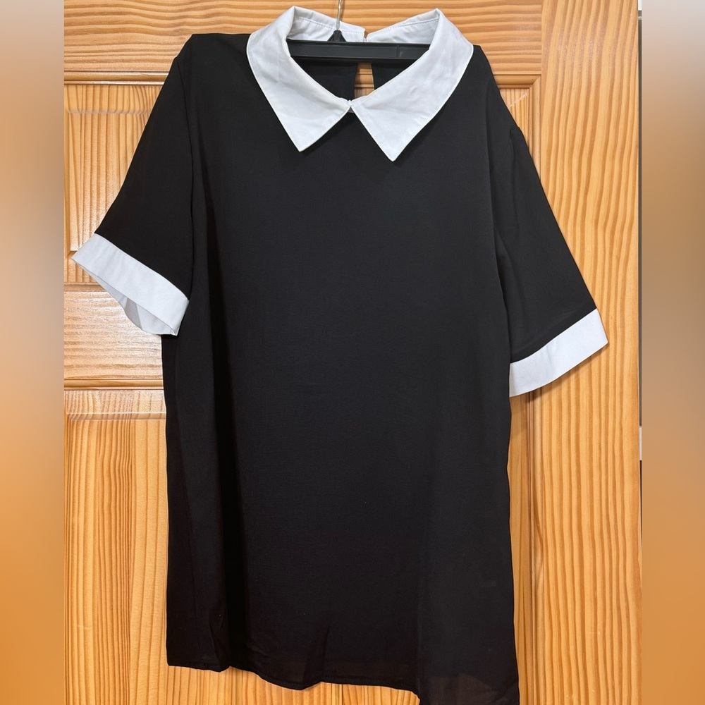Black top with white collar and white trim on sleeves